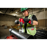 Person using a Milwaukee tool on a pipe in a warehouse setting
