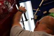 Person working on a red Toyota vehicle with Keco tools in a workshop.